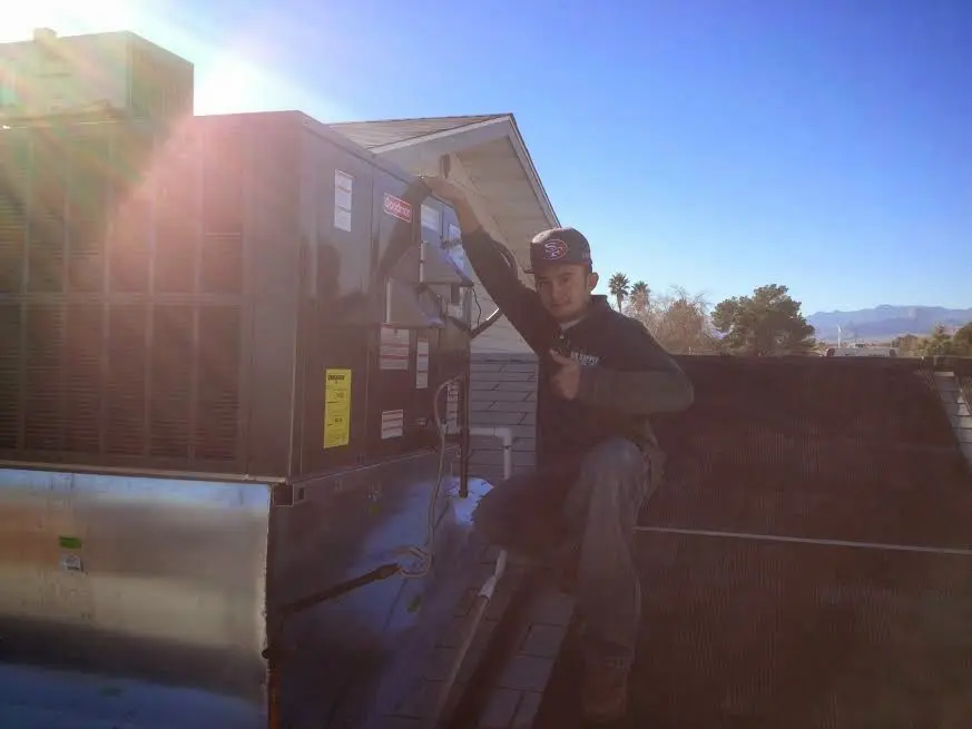 HVAC technician performing AC Tune-Up on a rooftop unit in St. Marys